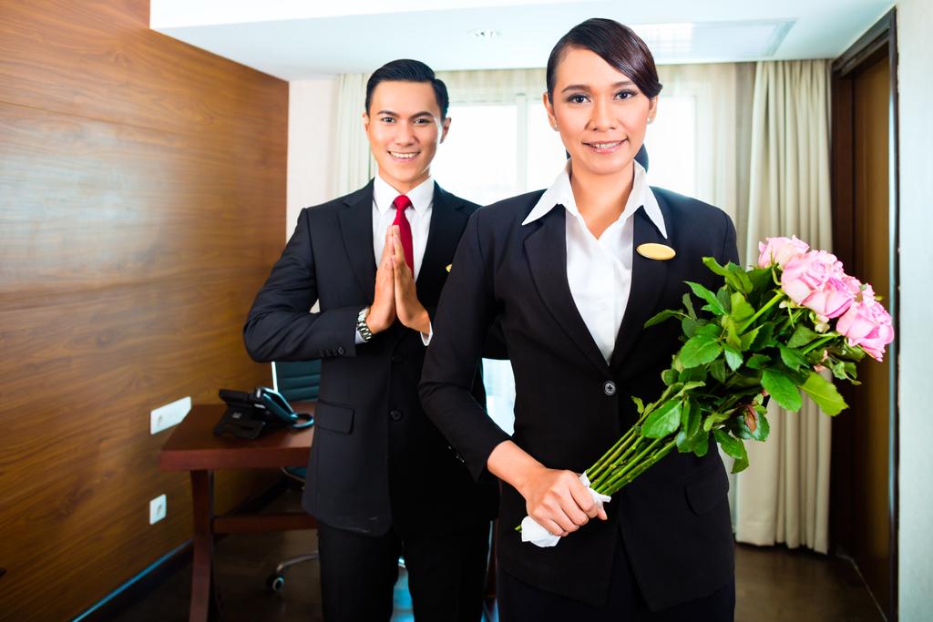 Asian hotel staff greeting with flowers